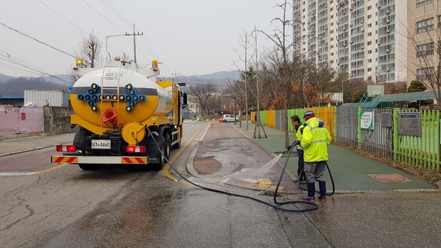 미세먼지를 씻어내기 위해 학교 주변을 물청소하고 있는 장면