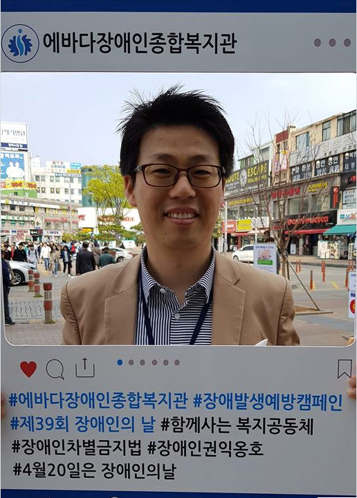 평택역 광장에서 팸플릿을 들고 있는 허종 사무국장이 환하게 웃고 있다.