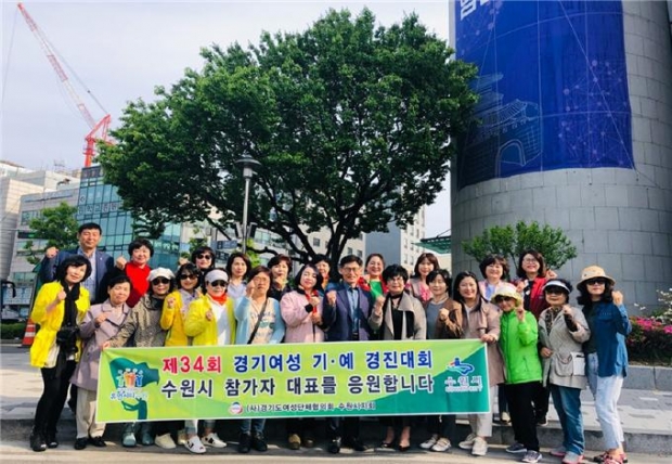 (사)경기도 여성단체협의회 수원시지회가 기·예 경진대회에 참가한 회원들을 현수막을 들고 응원하고 있다.