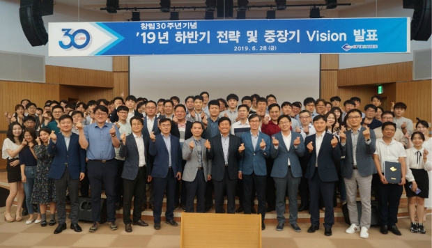 옵트론텍 창립 30주년 기념 ‘비전선포식’에 참석한 임직원이 기념사진을 찍고 있다
