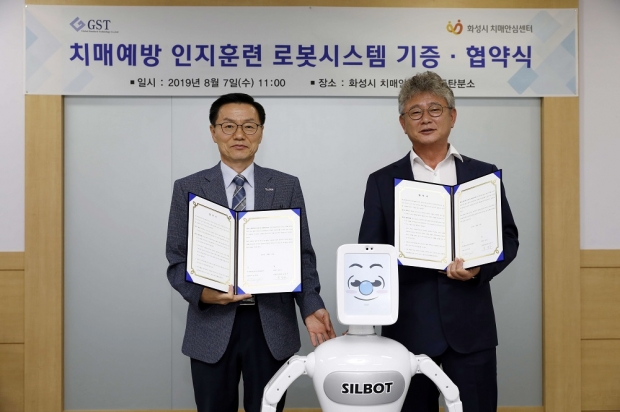 치매예방 인지 로봇 기증 협약 모습. 왼쪽부터 김장수 보건소장. 김덕준 글로벌스탠다드테크놀로지 대표이사.
