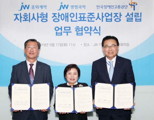 JW그룹은 서울 서초구 서초동 본사에서 17일 한국장애인고용공단과 ‘자회사형 장애인표준사업장’설립을 위한 협약식을 가졌다. JW중외제약 신영섭 대표(우), JW생명과학 차성남 대표(좌)와 한국장애인고용공단 조종란 이사장(가운데)이 협약서에 서명한 뒤, 기념촬영을 하고 있다.