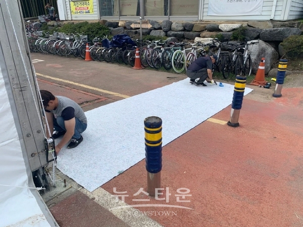 축제장 입구에 발 소득을 위한 부칙포를 설치하고 있다.