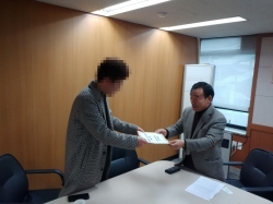 경기신문 관계자에게 항의 서한문을 전달하는 화성시 범대위 홍진선 상임위원장
