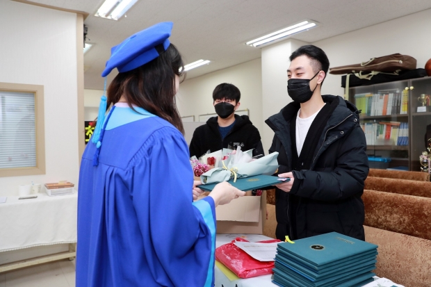 학과 사무실에서 학위증과 튤립을 나눠주고 있다