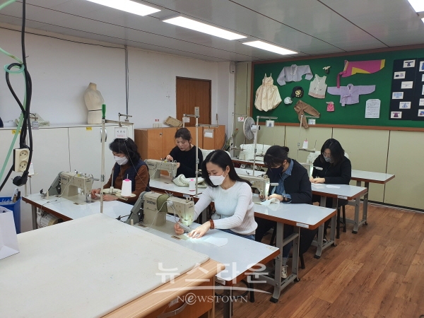 진주시 능력개발원 무지개동산회 회원들이 면 마스크를 제작하고 있다.