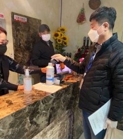다중이용시설에 소독약품 배부후 사용방법 설명하는 모습