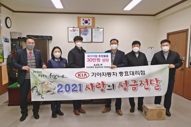 기아자동차 충효대리점 직원들이 용강동행정복지센터를 방문하여 후원물품을 전달하고, 고성달 동장과 함께 기념촬영을 하고 있다.
