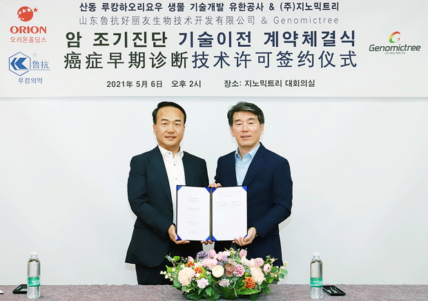 [사진설명] 지노믹트리 안성환 대표이사(사진 우측)와 ㈜오리온홀딩스(대표이사 허인철)의 중국 내 합자법인 ‘산둥루캉하오리요우생물기술개발유한공사’ 백용운 대표이사가 암 조기진단 기술이전 계약을 체결하고 기념사진을 촬영하고 있다.