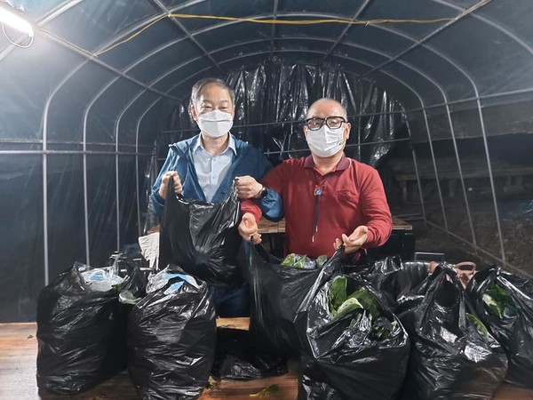 ▲ 대구천사후원회 이강문(오른쪽) 이사장과, 함께 참여한 장천식(왼쪽) 대구경북통합세탁업 회장이 시금치와 마스클 들어보이고 있는 모습이다.