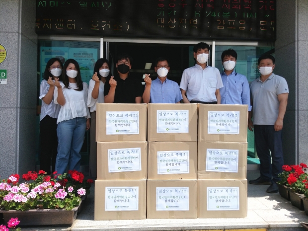 한국원자력환경공단에서 문무대왕면행정복지센터에 구호물품을 기탁하며 함께 단체 사진 촬영을 하는 모습