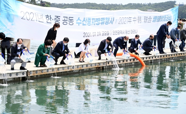 지난 9일 중구 왕산마리나에서 열린 '2021 한·중 공동 수산종자방류행사'에서 박영길 인천시 해양항공국장 등 내빈들이 참조기 치어를 방류하고 있다.