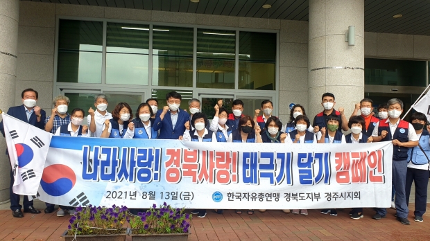 한국자유총연맹 경주시지회가 태극기 달기 캠페인 실시하며 기념촬영을 하고 있다.