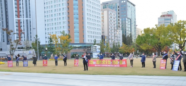 화수화평재개발조합원들이 성명서를 발표하며 피켓을 들고 성토하여 항의 의사를 표하고 있다.