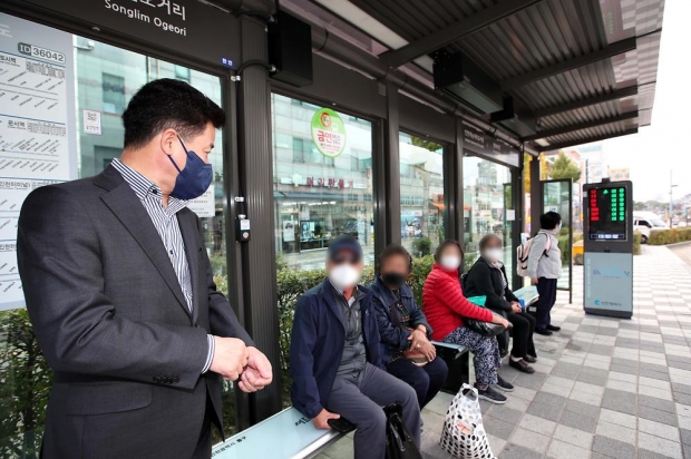 관내 버스승강장에 설치한 온열벤치를 직접 체험하며 주민들과 소통 중인 허인환 구청장이 현장 시찰을 하고 있다.