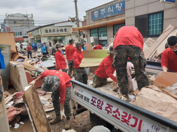 11일 오전 대송면 제내리 한 골목에서 해병대 장병들이 시에서 지원한 트럭으로 생활쓰레기를 담고 있다.
