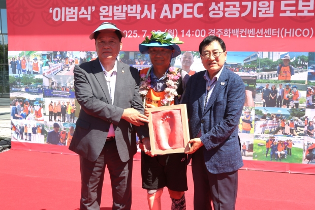 28일 경주화백컨벤션센터(HICO) 행사장에서 이범식(중앙) 박사가 왼발 완주 기념 풋프린팅 상패를 전달받고 주낙영(오른쪽) 경주시장, 이동협 경주시의회 의장과 함께 기념촬영을 하고 있다.