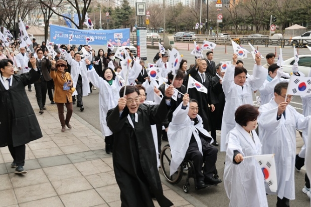 시민들이 태극기를 들고 시청 앞 도심을 걷는 ‘만세운동 거리행진’에 참여하고 있다.