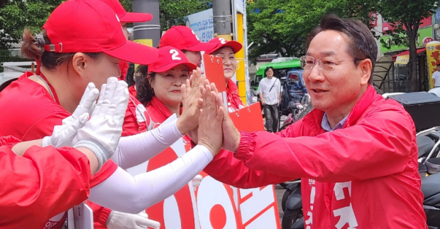 유정복 인천시장 후보가 23일 인천 남동구 동암역 유세에 앞서 운동원들과 하이파이브를 하고 있다.