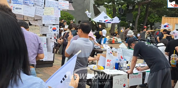 잠실 ‘재선거’ 캠페인에 동참해 현장에서 피켓과 태극기를 수작업으로 만들어 나눠주는 자원봉사자들/‘끝장보기라이브TV’ 화면 캡처