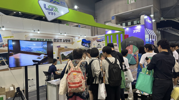 제11회 대한민국 국제 관광박람회 남양주시 홍보관에서 관람객들이 안내 리플렛을 받아보며 상담을 받고 있는 모습.