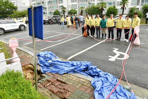 18일 박준 경상남도의회 의장과 도의원들이 집중호우로 싱크홀이 발생한 거제시 상동동 현장을 찾아 피해 상황과 추가 안전사고 위험을 점검하고 있다./사진=경남도의회