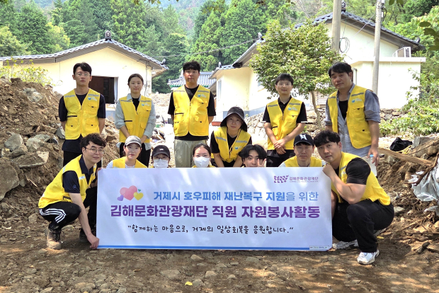 김해문화관광재단 직원들이 집중호우 피해를 입은 거제시 거제면 벽수암에서 복구 봉사활동을 마친 뒤 기념촬영을 하고 있다./사진=김해시