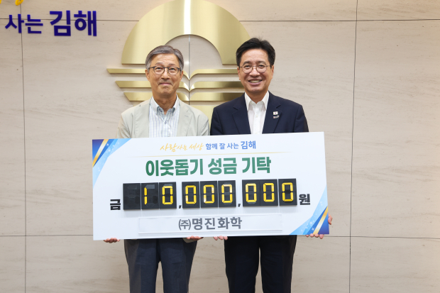 김민재 ㈜명진화학 대표(왼쪽)가 4일 취약계층을 위한 이웃돕기 성금 1천만원을 기탁한 뒤 정영두 김해시장과 기념촬영을 하고 있다./사진=김해시