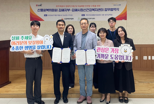 김해시정신건강복지센터와 신용회복위원회 김해지부 관계자들이 취약계층의 경제적 자립과 자살예방 안전망 구축을 위한 업무협약을 체결한 뒤 기념촬영을 하고 있다./사진=김해시