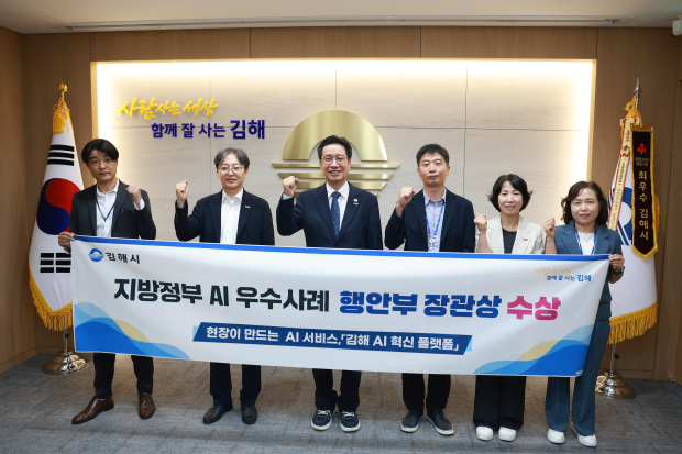 정영두 김해시장(사진 중앙)과 관계 공무원들이 ‘2026 지방정부 AI 우수사례 발표대회’ 행정안전부장관상 수상을 기념하며 기념촬영을 하고 있다./사진=김해시