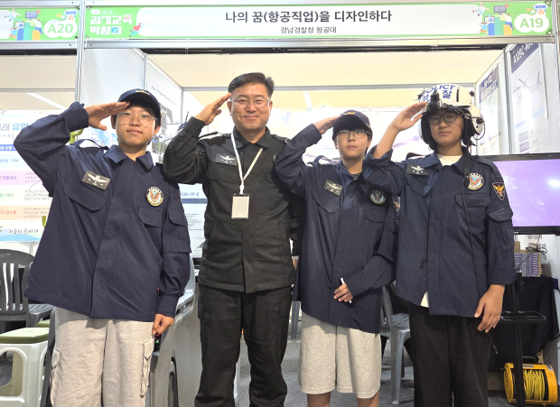 김해지역 학생들이 지난 19일 김해문화의전당에서 열린 ‘2026 꿈 이음 김해교육박람회’에서 조종복과 조종 헬멧을 착용하고 경찰항공대원과 함께 1일 조종사 체험을 하고 있다./사진=경남경찰청